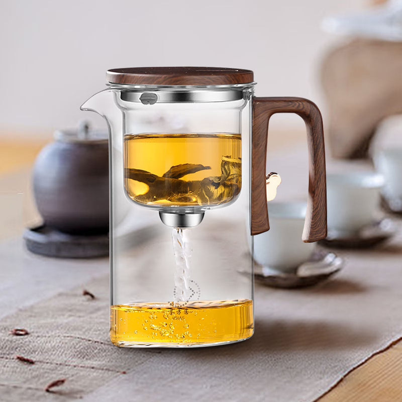 Magnetic glass tea pot releasing brewed tea from the infuser into the pot