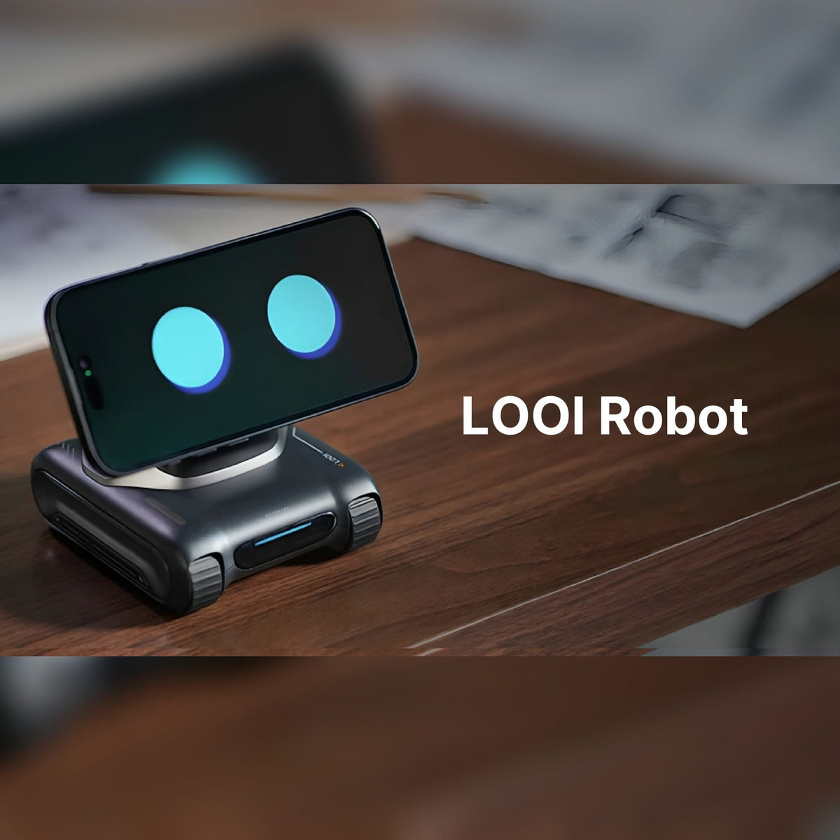 LOOI desktop robot with a smartphone showing animated eyes on a wooden desk