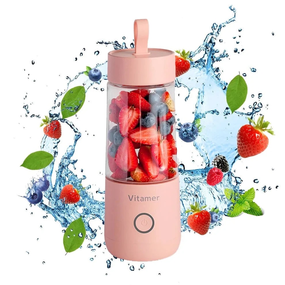 Pink portable electric blender filled with strawberries and blueberries