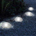 Solar stone garden lights glowing along a gravel path at night